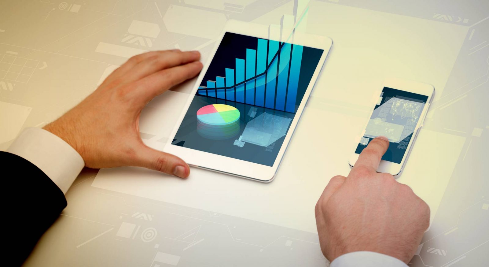 a person holding a smart phone next to a tablet.