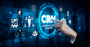 A person is pointing at a crm icon on a screen.