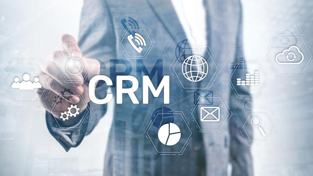 A man in a suit is pointing at the word crm.