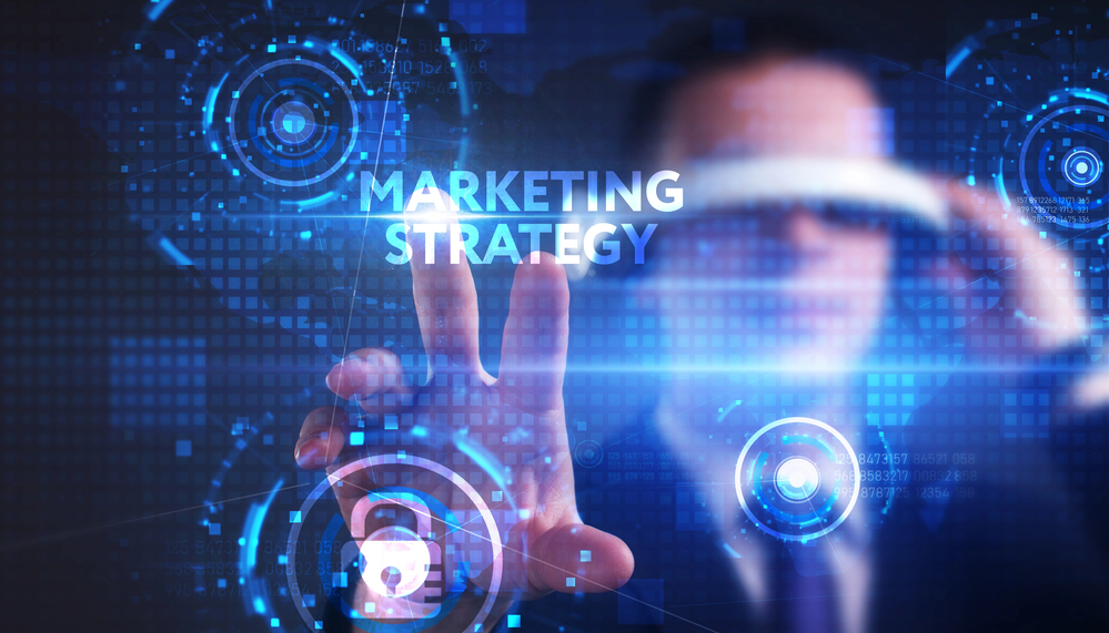 A man in a business suit is touching a screen with the word marketing strategy.