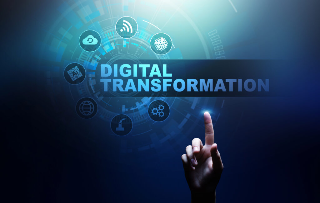 A finger pointing at "Digital Transformation" text surrounded by digital and technology icons on a blue digital background.