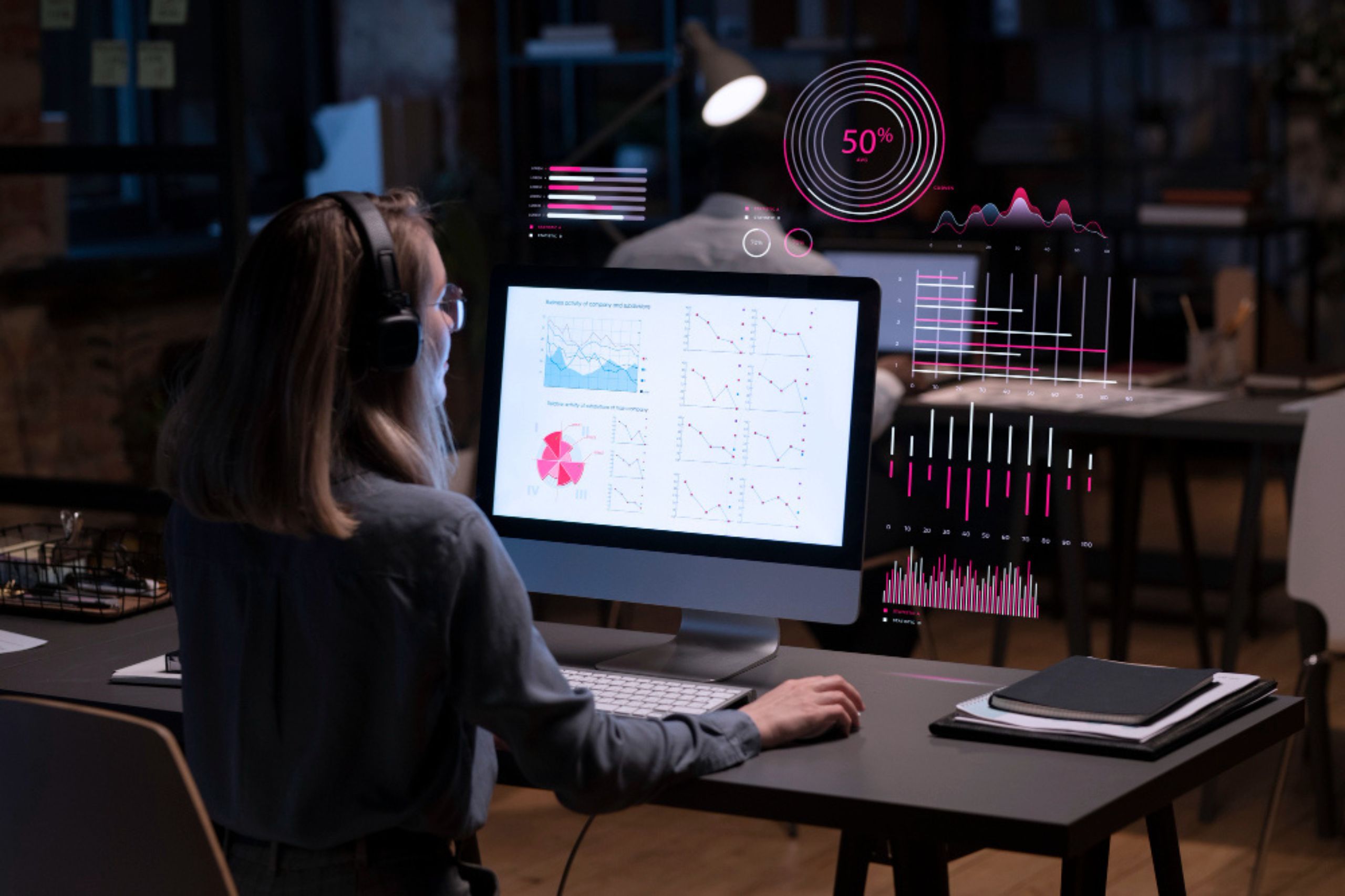A person wearing headphones sits at a desk, analyzing charts and graphs on a computer monitor with digital data visualizations overlaid.